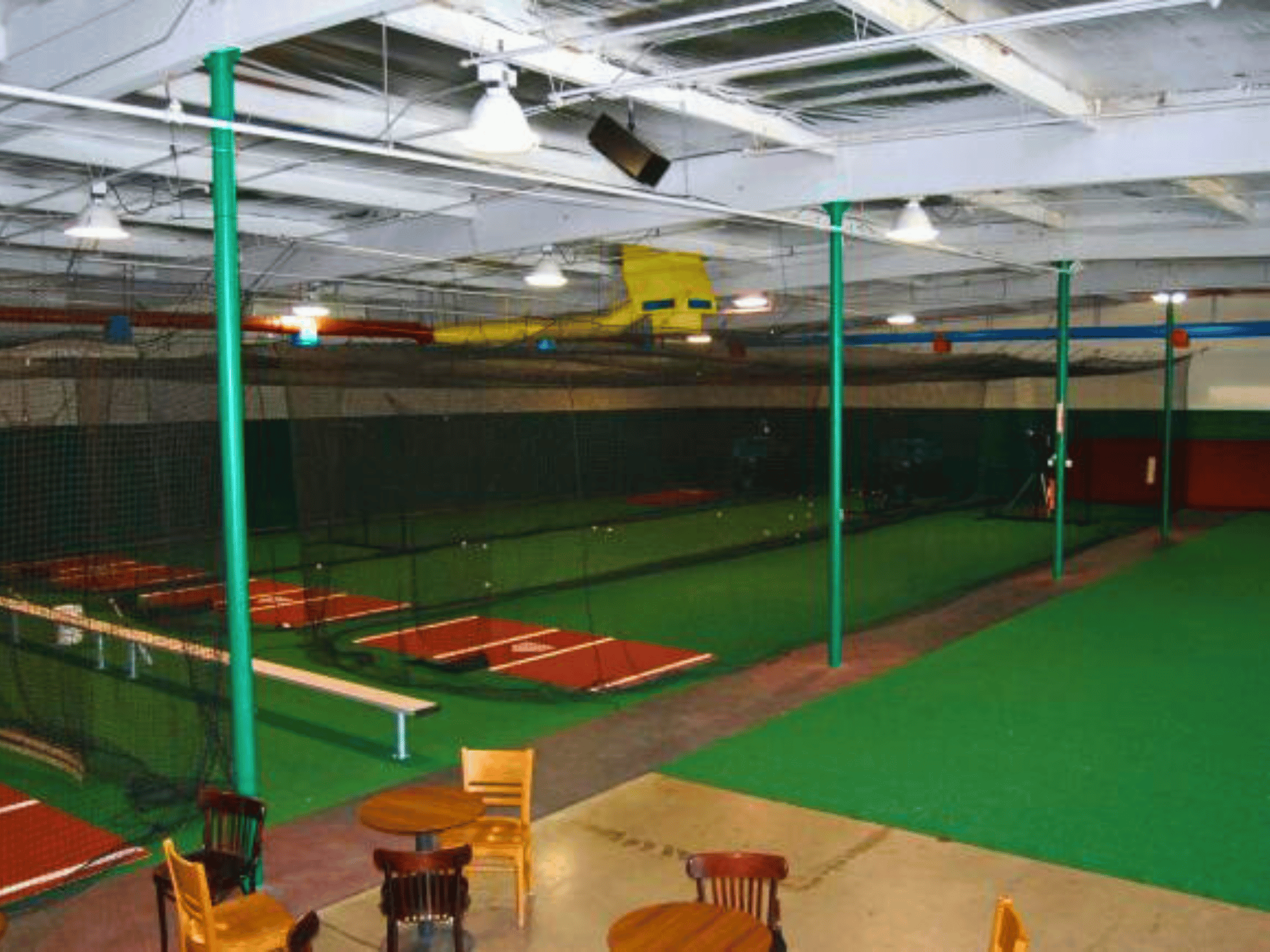 Indoor batting cage facility with three lanes and batters box mats