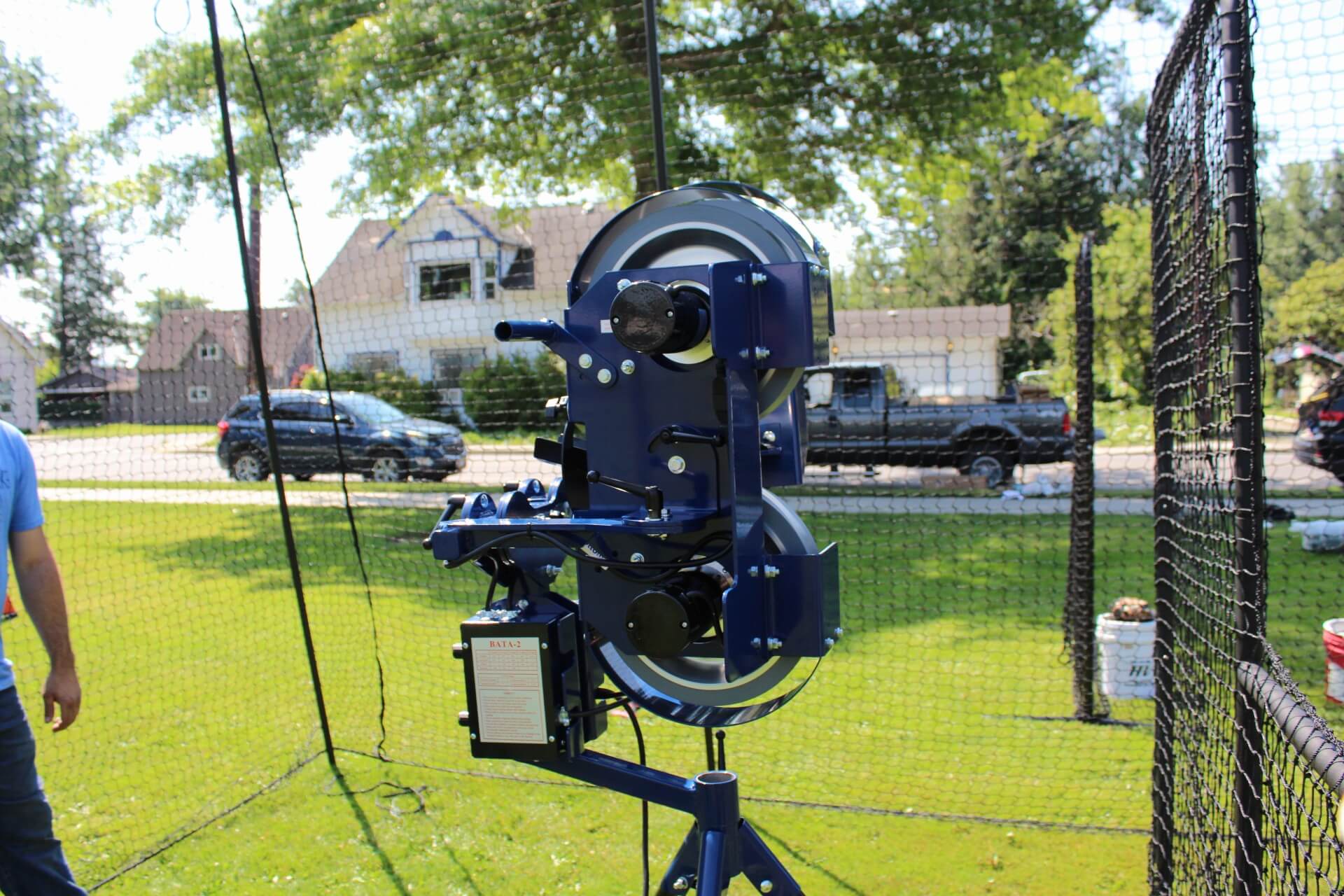 Bata 2 pitch 3 pitching machine inside the trapezoid batting cage and behind the standard L-screen