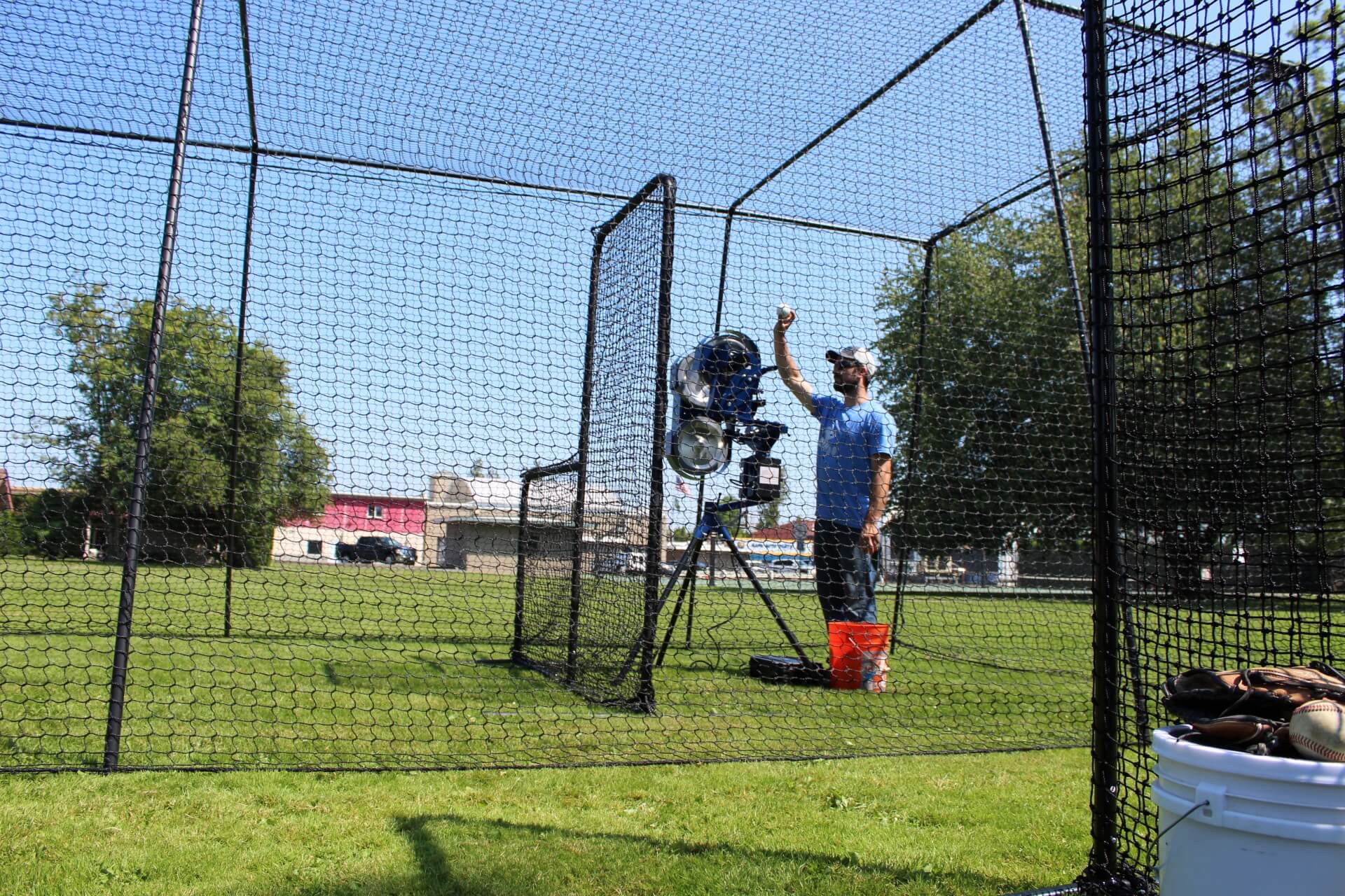 Bata 2 pitch 3 pitching machine inside the trapezoid batting cage and behind the standard L-screen