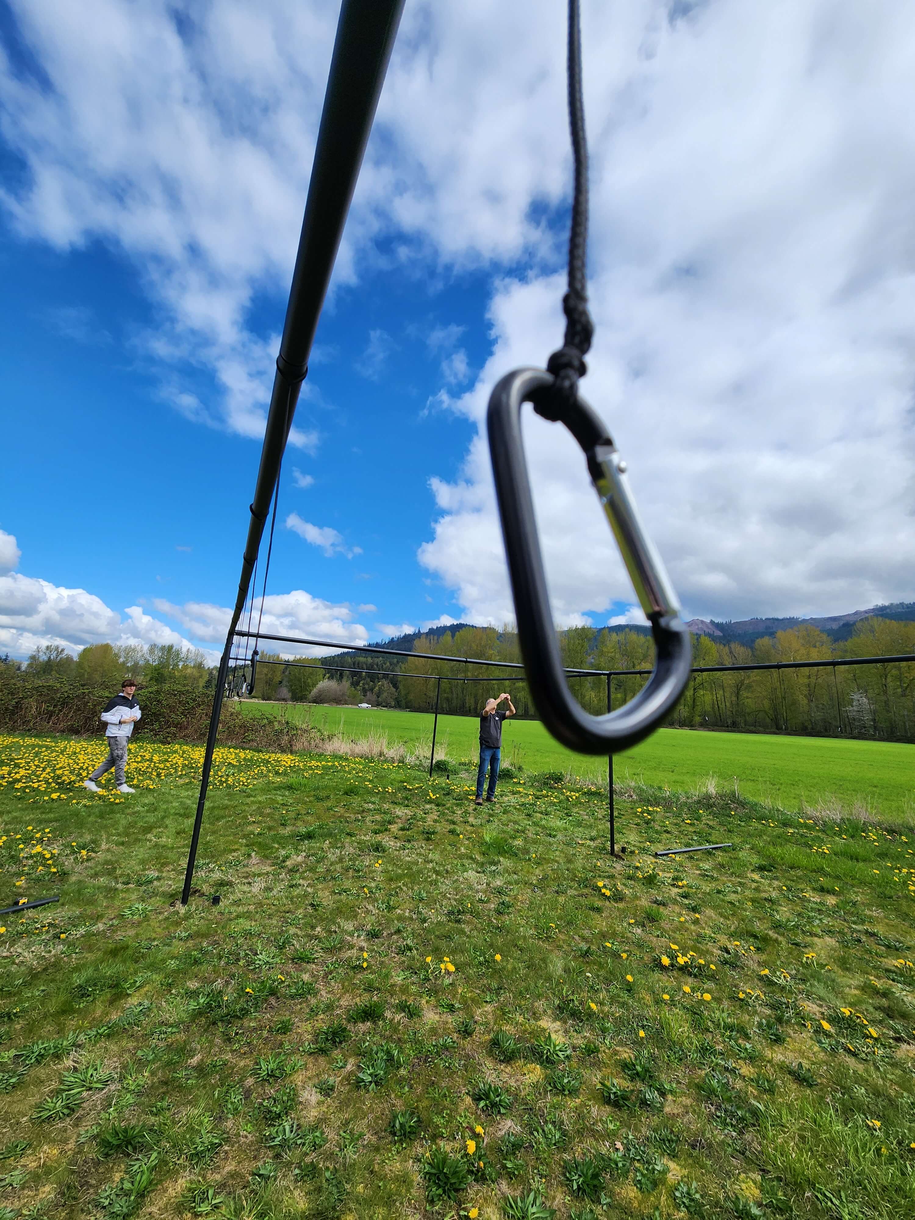 Carabiner clip hanging from batting cage poles