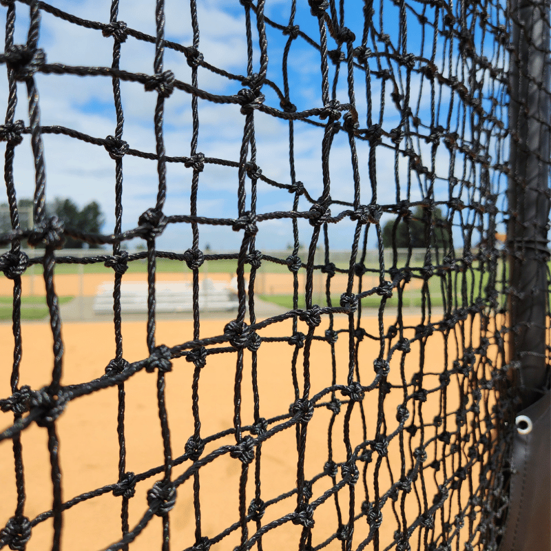 Close up view of the armadillo l-screen netting with baseball infield behind it