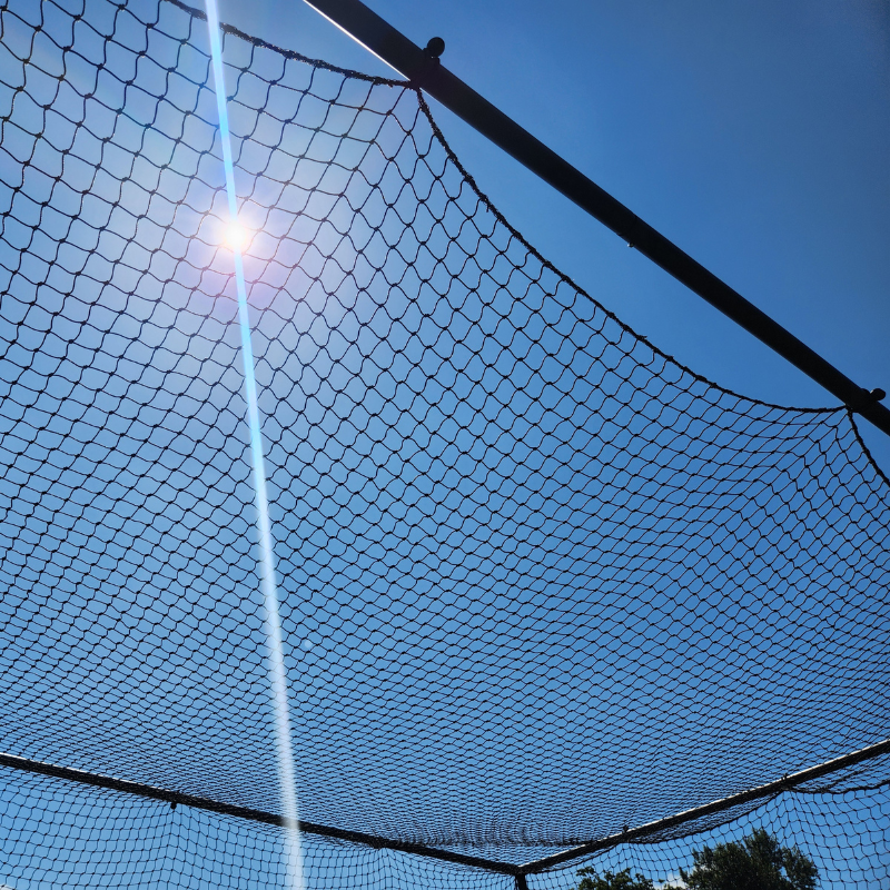 BCI Portable backstop close up of the top with blue skys and sun