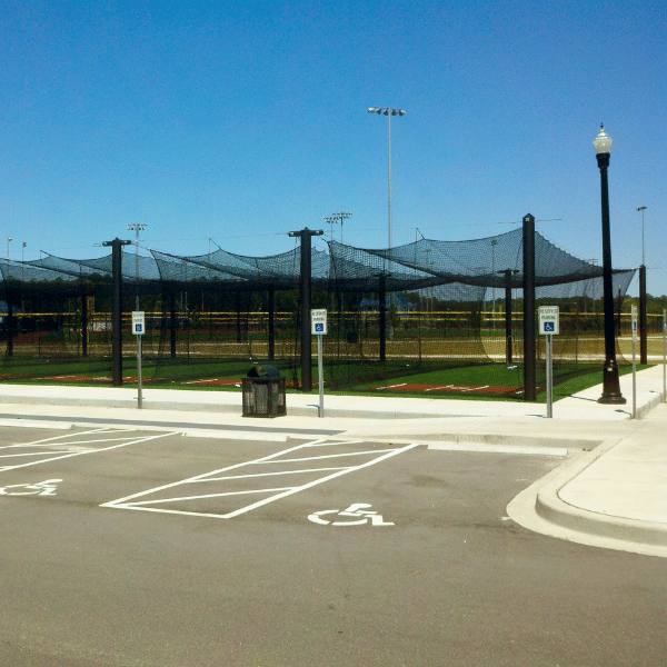 Large Mastodon batting cage in front of a sport complex parking lot