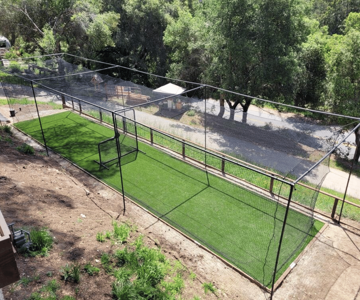 Thumper batting cage with green turf inside