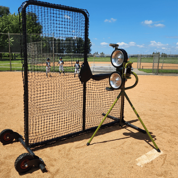 The Mound Yeti 2 Pitching Machine behind the Armadillo L-Screen on baseball infield