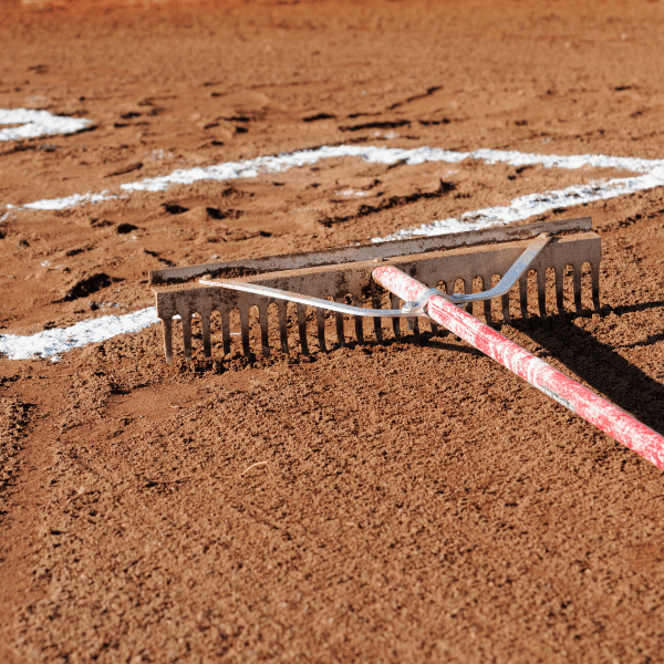 Rake laying on baseball infield dirt