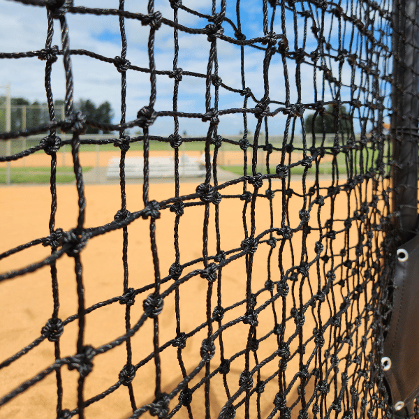 Armadillo L-screen netting close up with baseball infield behind it