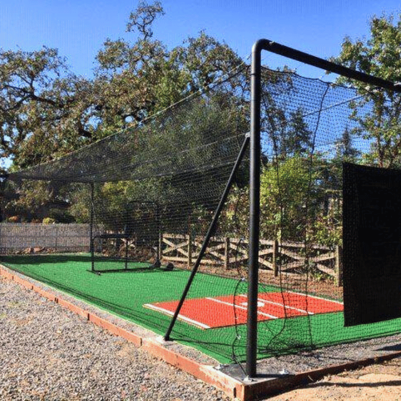 Iron Horse Batting Cage System with trees, blue skies, the armadillo, and deluxe batters box mat inside