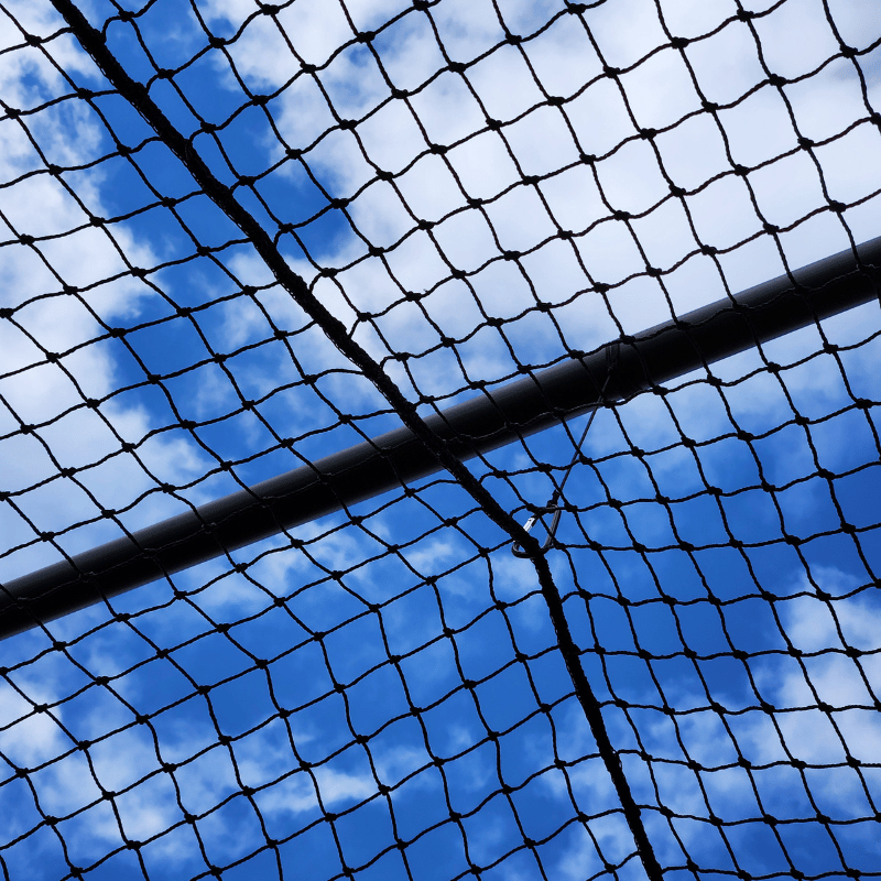 Close up of the batting cage netting attached to the cross poles of the thumper batting cage