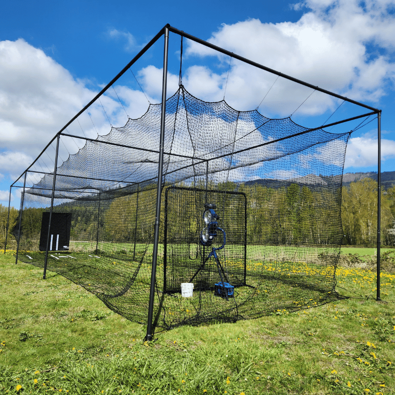 The Thumper Ultra Batting Cage with the bata 2, vinyl backdrop, and other accessories with blue cloudy skys above