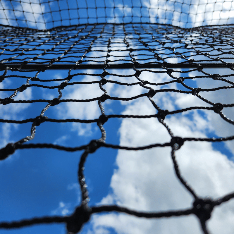 #42 HDPE batting cage netting close up with blue skys