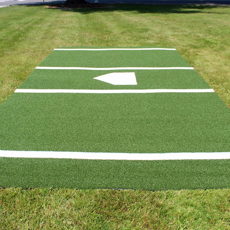 Green Deluxe Batter's Box Mat laying on green grass