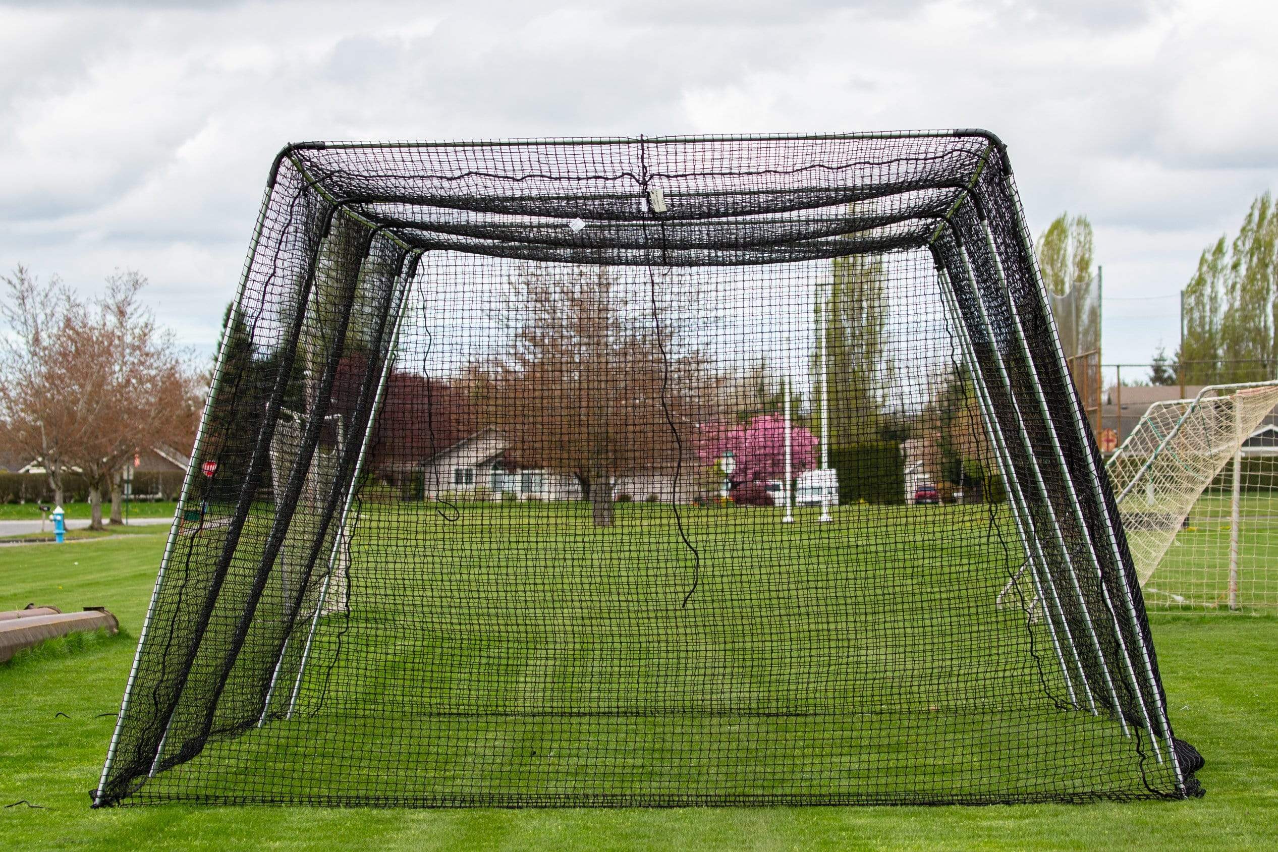 Freestanding Trapezoid Batting Cage on field grass
