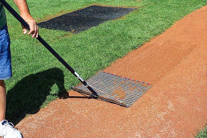 Man using Steelmat Drag Mop to clean baseball infield