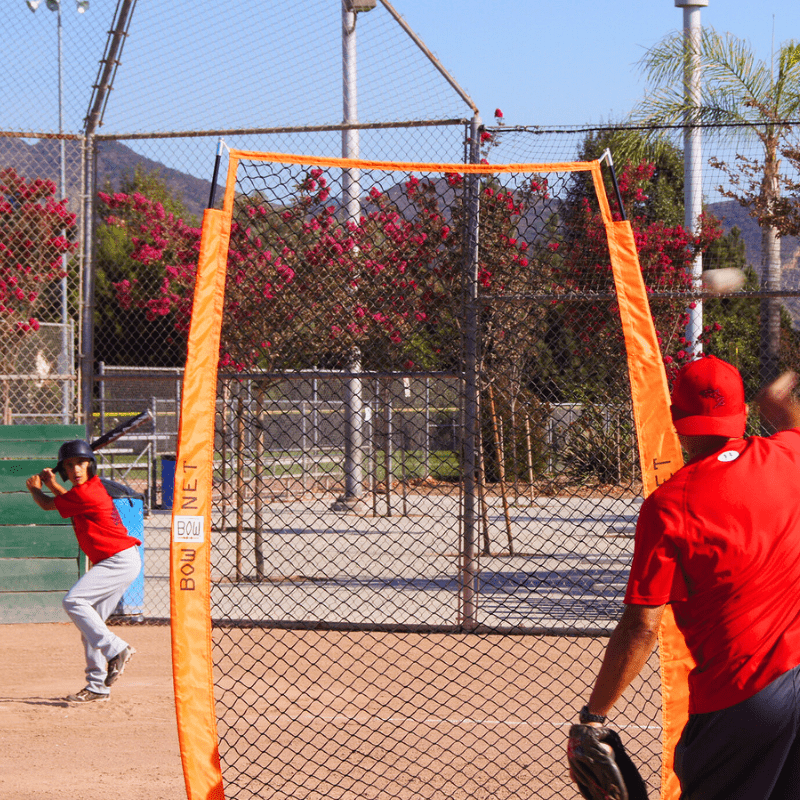 Man pitching to batter with the Protective I Screen in front of him