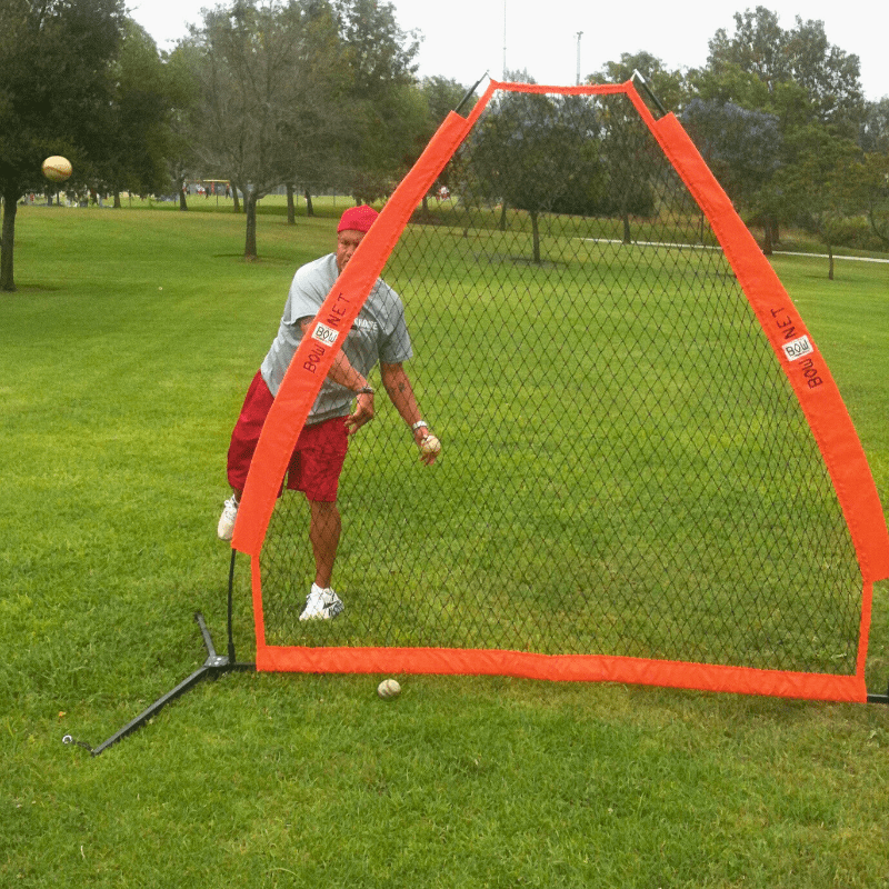 Man pitching to batter with the Protective Travel Screen in front of him
