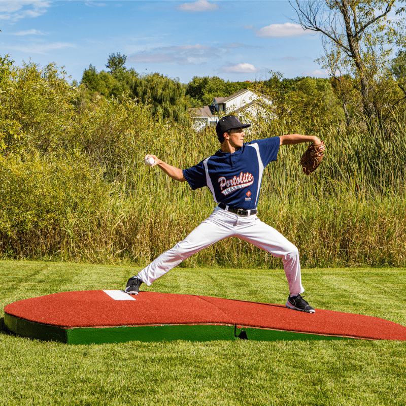 Man pitching off of the 2 Piece Indoor Practice Mound with Turf Red